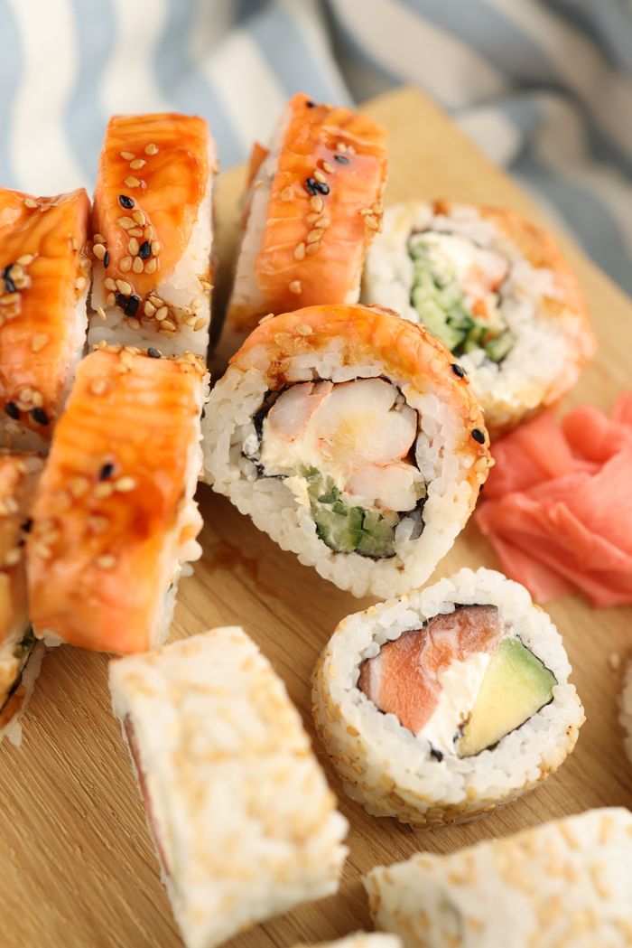 Delicious sushi rolls with rice and seafood on a wooden board, perfect for food photography.