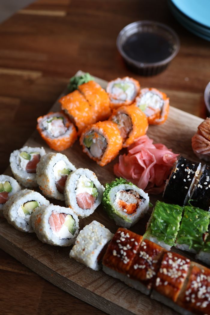 Delicious sushi assortment with salmon, avocado, and more on a wooden board.